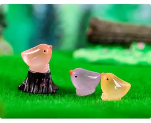 Miniature resin bird figurine detail shot, cute glowing animal decor for fairy garden moss scape.