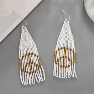 Handmade bohemian beaded fringe earrings featuring white and gold peace sign design details.
