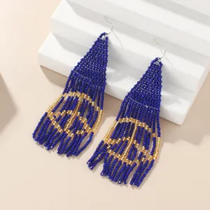 Detailed close-up of handmade bohemian blue and gold beaded fringe earrings texture design.