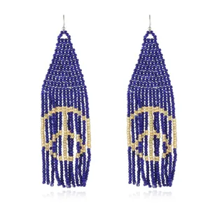 Close-up detail of bohemian handmade blue and gold seed bead fringe earrings with peace sign motif.