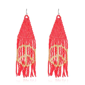 Detailed close-up of Bohemian red and gold seed bead fringe earrings showing intricate weaving.