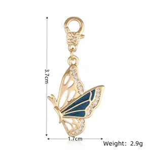 Colgante de mariposa de cobre chapado en oro con esmalte azul y piedras de circonio.