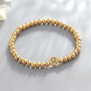 Stainless steel zodiac beaded bracelet detail, gold-colored metal charm jewelry for women.