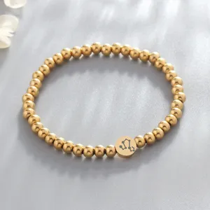 Gold stainless steel bead bracelet detail view featuring a delicate Leo constellation charm.
