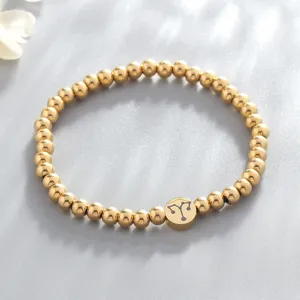 Gold stainless steel beaded bracelet featuring a zodiac sign charm for women, detail shot.