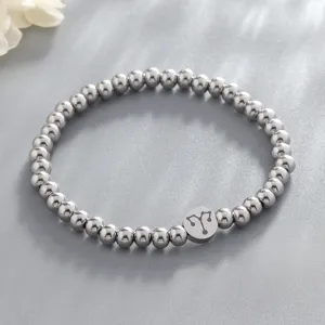 Close-up view of stainless steel beaded zodiac charm bracelet detail on grey textured background.