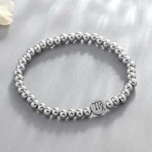 Detailed view of the stainless steel bead bracelet featuring a zodiac charm symbol.