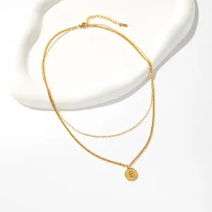 Close up detail of double layer stainless steel letter E pendant necklace stylish jewelry.