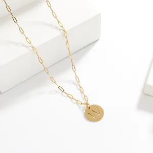 Closeup of the gold paperclip chain necklace featuring a stylish cutout letter W pendant.
