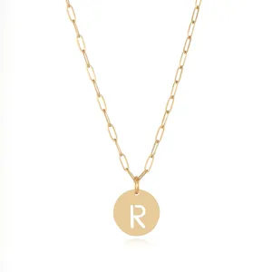 Close-up detail of a gold stainless steel letter R pendant necklace, stylish jewelry accessory.