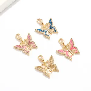 Vista detallada de dijes de mariposa de esmalte con pedrería de cristal y cierre metálico.