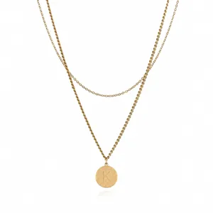 Detailed view of the double-layer gold chain necklace featuring a round letter K pendant.