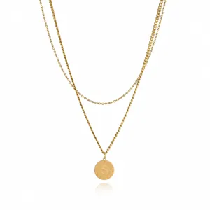 Gold layered necklace detail showing the delicate double chain and letter S pendant.