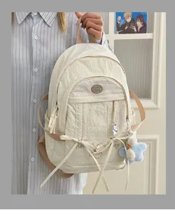 Korean casual student backpack detail view, cute nylon bookbag with ribbon bows and charms.