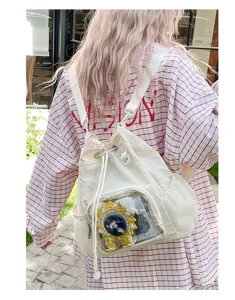 Dettaglio della finestra trasparente dello zaino ita bianco in tela con spille anime.