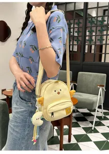 Detailed close-up view of the cute cartoon chick canvas crossbody bag with plush charm.