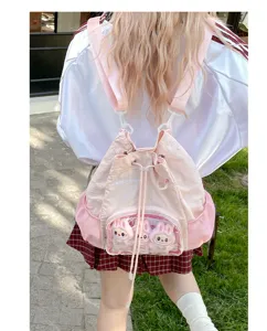Zaino ita rosa con tasca frontale trasparente e tre simpatiche bambole di peluche di coniglio.