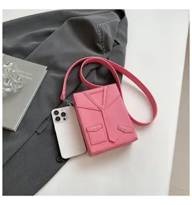 Primo piano della borsa a tracolla rosa a forma di giacca con dettagli di risvolto unici.