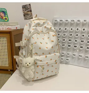 Floral pattern school backpack with cute bear pendant, lightweight casual travel daypack.
