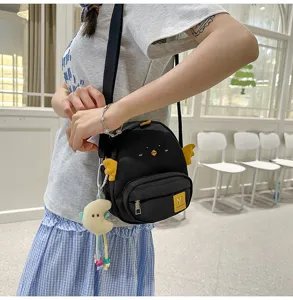 Cute black chick crossbody bag with yellow wings and pendant for cute everyday student style.