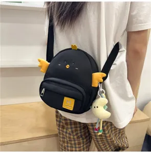 Close-up detail of cute cartoon chick crossbody bag with yellow wings and front pocket.