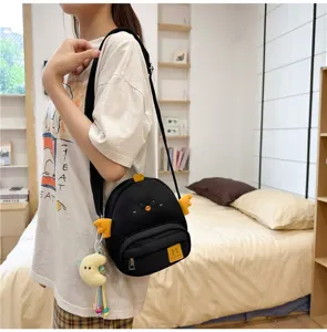 Cute black chick crossbody bag for women, Japanese style cartoon canvas shoulder bag with plush pendant.