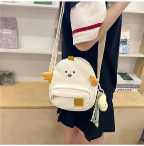 Cute chick canvas crossbody bag for girls, casual student shoulder bag with cute doll pendant.