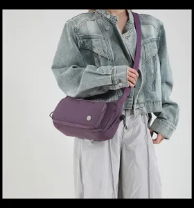 Dettaglio borsa a tracolla impermeabile viola, cinghia regolabile, borsa casual molto leggera.
