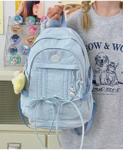 Light blue nylon casual student backpack detail, featuring cute bows, embroidery and front pocket.