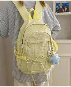 Nylon backpack detail, light yellow student bookbag featuring cute embroidery and pendants.