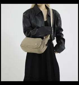 Dettaglio di una borsa a tracolla impermeabile in nylon da donna con cinturino regolabile.