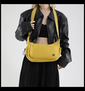 Vista dettagliata della borsa a tracolla in nylon giallo, con tasca frontale e tracolla.