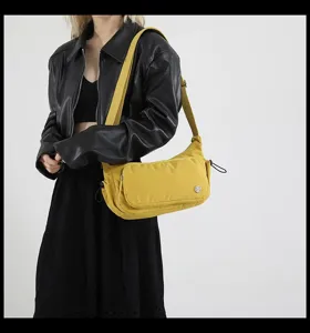 Dettaglio di una elegante borsa a tracolla in nylon giallo brillante con tasca anteriore.