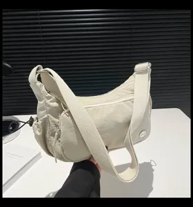Vista dettagliata della borsa a tracolla leggera in nylon con tasche multiple e comoda bretella.