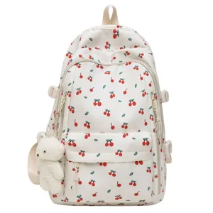 White cherry print school backpack with cute bear pendant for girls and students daily commuting.