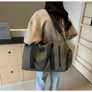 Vue détaillée d'un grand sac de voyage avec poignées robustes et poche latérale zippée.