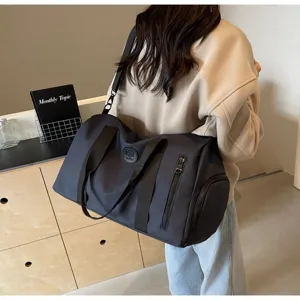 Grand sac de voyage étanche sport fitness pour femme avec poche zippée latérale pratique.