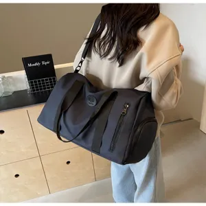 Grand sac de voyage et de sport spacieux, en nylon durable avec plusieurs poches pratiques.