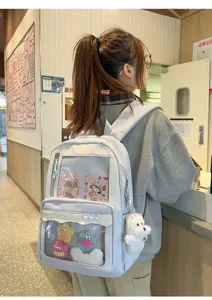 Gros plan sur la fenêtre avant transparente et les charmants pendentifs de ce sac à dos.