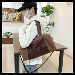 Brown travel gym duffel bag detail showing mesh pocket and strap design for daily sports.