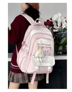 Detailansicht des rosa Studentenrucksacks mit vielen Fächern und niedlichem Plüschanhänger.