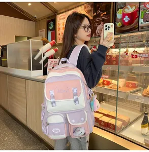 Szenendetail des frischen Studentenrucksacks in Rosa und Lila mit mehreren Taschen.