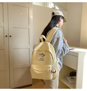 Close up view of stylish canvas backpack showcasing cute puppy embroidery and casual daily style.