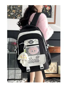 Schwarz-weißer Studentenrucksack mit großem Volumen, süßem Cartoon-Print und Plüschanhänger.