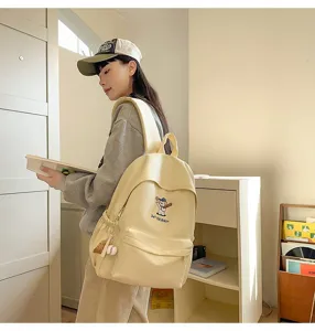 Detailed view of the cute light yellow canvas backpack featuring baseball dog embroidery.