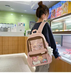 Vue détaillée du sac à dos ita rose et marron avec fenêtre transparente pour badges et breloques.