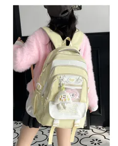Detailansicht des niedlichen Schulrucksacks in Pastellgelb und WeiB mit stilvollem Anhanger.