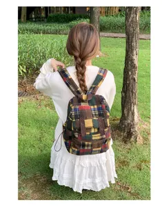 Detailed view of vintage plaid backpack outdoor scene, showing fabric texture and design.