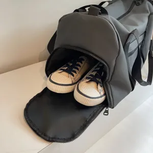 Vue détaillée du sac de sport gris montrant le compartiment à chaussures zippé pratique.