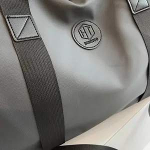 Vue de détail d'un grand sac de sport imperméable avec des sangles noires robustes pour les voyages.